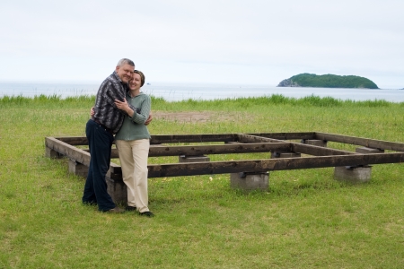 Happy middle aged couple in the construction of a house by the sea.の写真素材