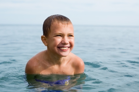 Joyful boy swims in the sea.の写真素材