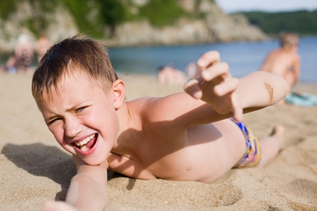 Emotional boy resting on the beach.の写真素材