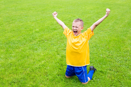Excited boy football player after goal scoredの写真素材