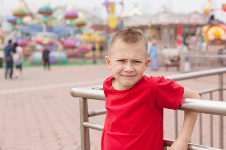 Boy in the amusement park on a background of carouselsの写真素材