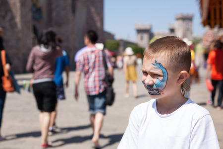 Boy painting face with shark in amusement park.の写真素材
