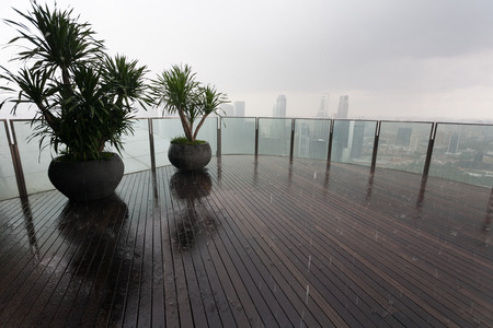 On the lookout of a skyscraper in the rain with views of Singapore の写真素材