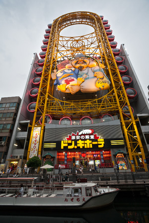 OSAKA, JAPAN - MAY 28, 2008: Ferris wheel on the banks of the Dotonbori Canal. Dotonbori area is very popular among tourists and locals, here are the many restaurants and cafes, shops and nightlife.のeditorial素材