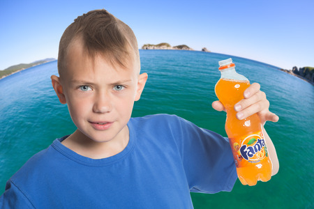 NAKHODKA, RUSSIA - MAY 10, 2014: Boy holding a bottle of drink Fanta produces Coca-Cola Company. Fanta is a very popular soft drink, sold in vending machines, stores and restaurants around the world.のeditorial素材