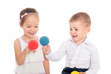Joyful Asian girl and European boy playing with balls.の写真素材