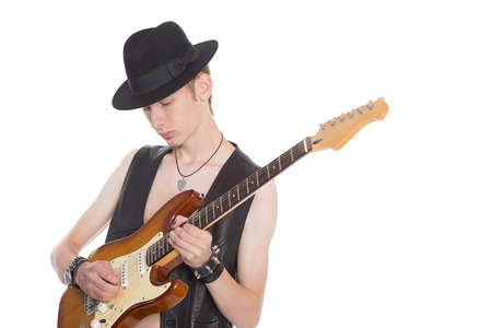Young musician with hat playing on electric guitar.