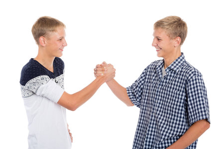 Young twin brothers shake hands, isolated on whiteの写真素材