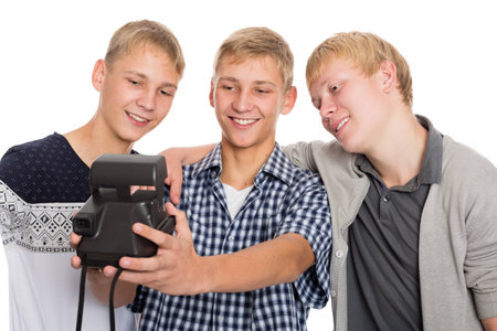 Three friends taking self on old camera instant print. Two of the boys twin brothers.の写真素材