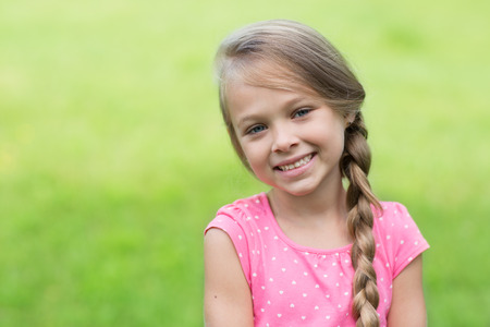 Smiling blond girl with braid. Girl seven years.の写真素材