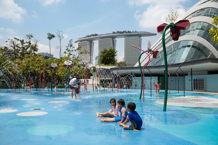 SINGAPORE - JANUARY 27, 2015: Happy children playing on the playground with water attractions in the popular park Gardens by the Bay. Park was opened in 2012 and is a striking sight of Singapore.のeditorial素材