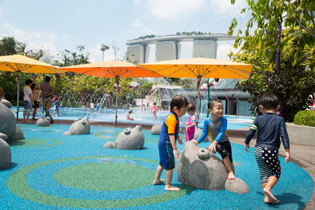 SINGAPORE - JANUARY 27, 2015: Happy children playing on the playground with water attractions in the popular park Gardens by the Bay. Park was opened in 2012 and is a striking sight of Singapore.のeditorial素材