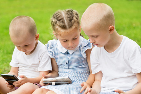 Children are taught the game on your smartphones. Summer parkの写真素材