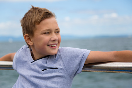 Smiling boy on the promenade by the seaの写真素材