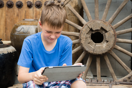 European boy used tablet PC being in the famous Panjiayuan Antique Market in Beijingの写真素材