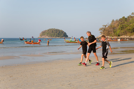 KATA BEACH, THAILAND - CIRCA FEBRUARY, 2015:  People in the early morning on the beach of Kata. This is one of the most popular beaches among tourists in Phuket.のeditorial素材