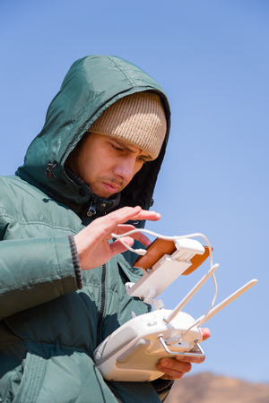 Man controls the radio-controlled drone in the spring