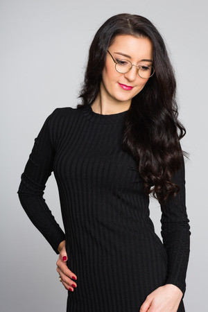 Portrait of a beautiful girl with black hair on gray. Age 32 years.の写真素材