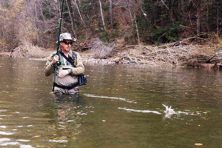 Fisherman caught grayling and pulls him out of the river
の写真素材