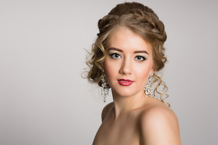 Charming blonde with naked shoulders against a gray backgroundの写真素材