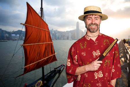 European man in a traditional Chinese costume against the background of Hong Kongの写真素材
