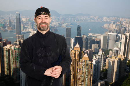 European man in traditional Chinese costume at the Victoria peak in Hong Kongの写真素材
