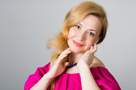 Portrait of a 39 year old woman in a pink dressの写真素材