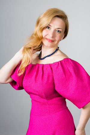 Portrait of a 39 year old woman in a pink dressの写真素材