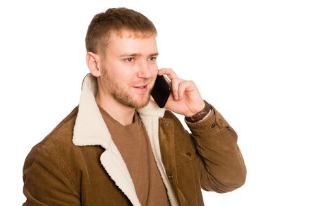 Young European man talking on a smartphone. Isolated on white.の写真素材