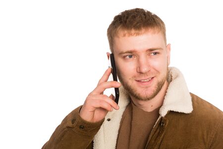 Young handsome man talking on a smartphone. Isolated on white.の写真素材