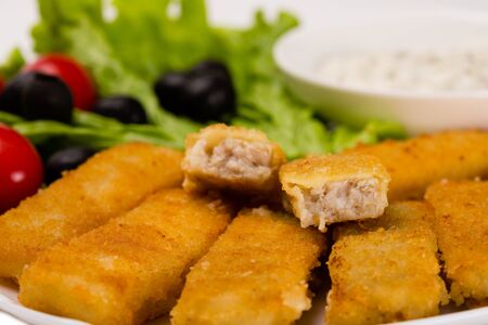 Fried fish fingers with vegetables close up. Isolated on white.の写真素材