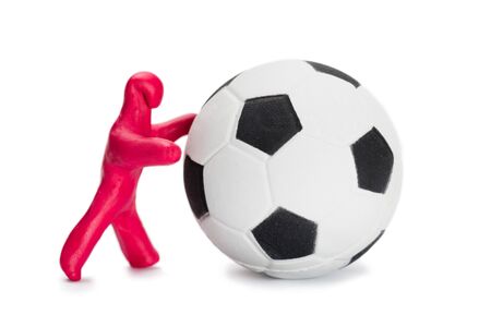 Plasticine small person soccer player with a soccer ball isolated on whiteの写真素材