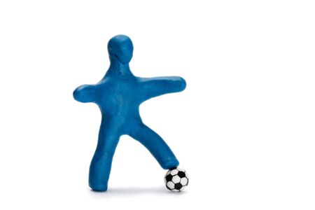 Plasticine small person soccer player with a ball isolated on whiteの写真素材