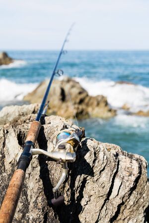 Spinning for fishing on the rocks by the seaの写真素材