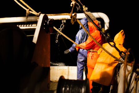 Fishermen choose a trawl with fish aboard at night in the Sea of Japanの写真素材