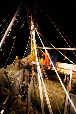 Fishermen choose a trawl with fish on board the ship in Japanese Seaの写真素材