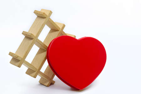 Red heart with a wooden decorative grid on a white background.の写真素材
