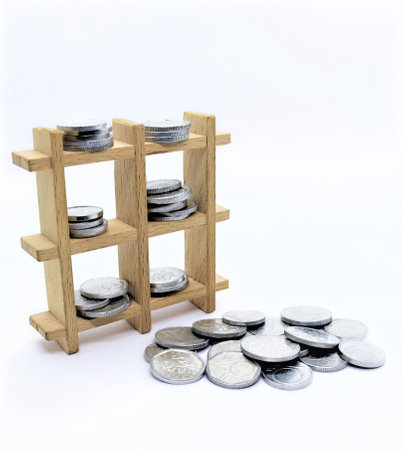 Wooden decorative grid with coins. Coins on the ground. Coins on a shelf. Money lies everywhere, let's make big money. White background.の写真素材