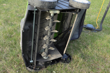 A scarifier laid on its side on the grass. Detail of scarifier blade. The lower part. Improving lawn quality.の写真素材