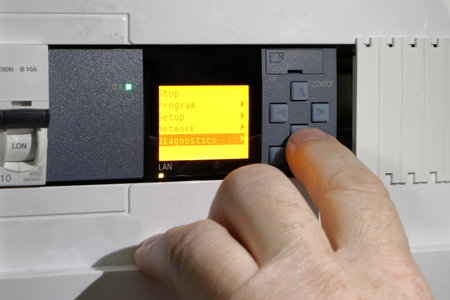 An electrical engineer diagnoses a programmable relay. Close up of a hand setting up a PLC.  Testing and programming of an industrial control system.の写真素材