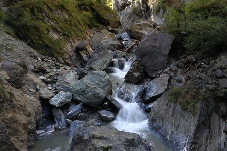 Motion photo of a waterfall. Water flowing between rock formations. Kitzlochklamm Taxenbach gorge in Alpine region.の写真素材