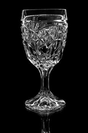 crystal brandy glass with backlight on a black background with reflectionの写真素材