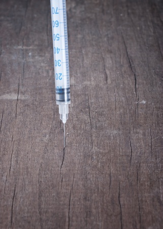 syringe into a wooden boardの写真素材