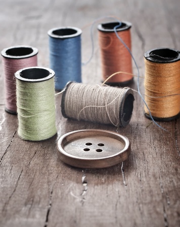 	Many bobbin of thread with needle and button on tableの写真素材