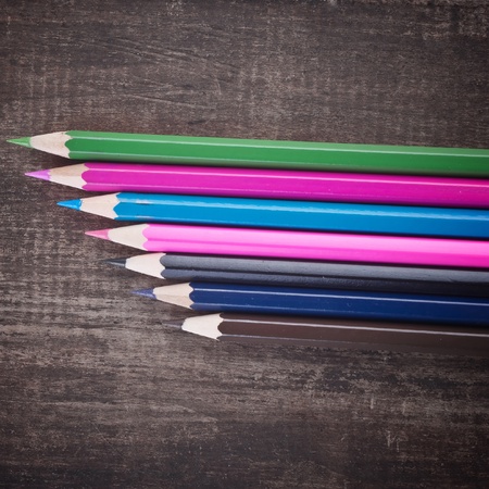 colored pencils on old wooden plankの写真素材