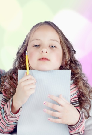 little girl with notebook and pen in bedの写真素材