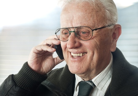 Senior businessman with phone  portrait の写真素材