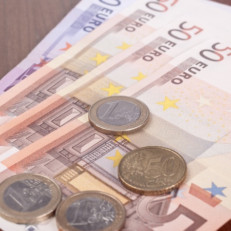 Close up of Euro coins on 50 Euro notes