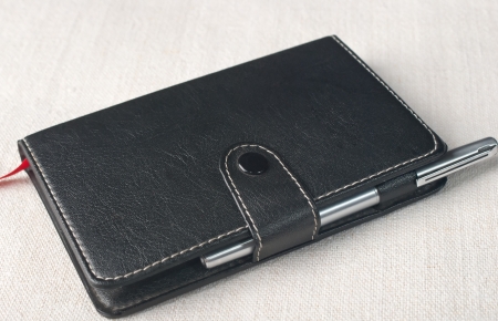 Leather notebook and pen on the tableの写真素材