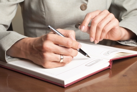 Business Woman Writing with pen in notepad,close up photoの写真素材